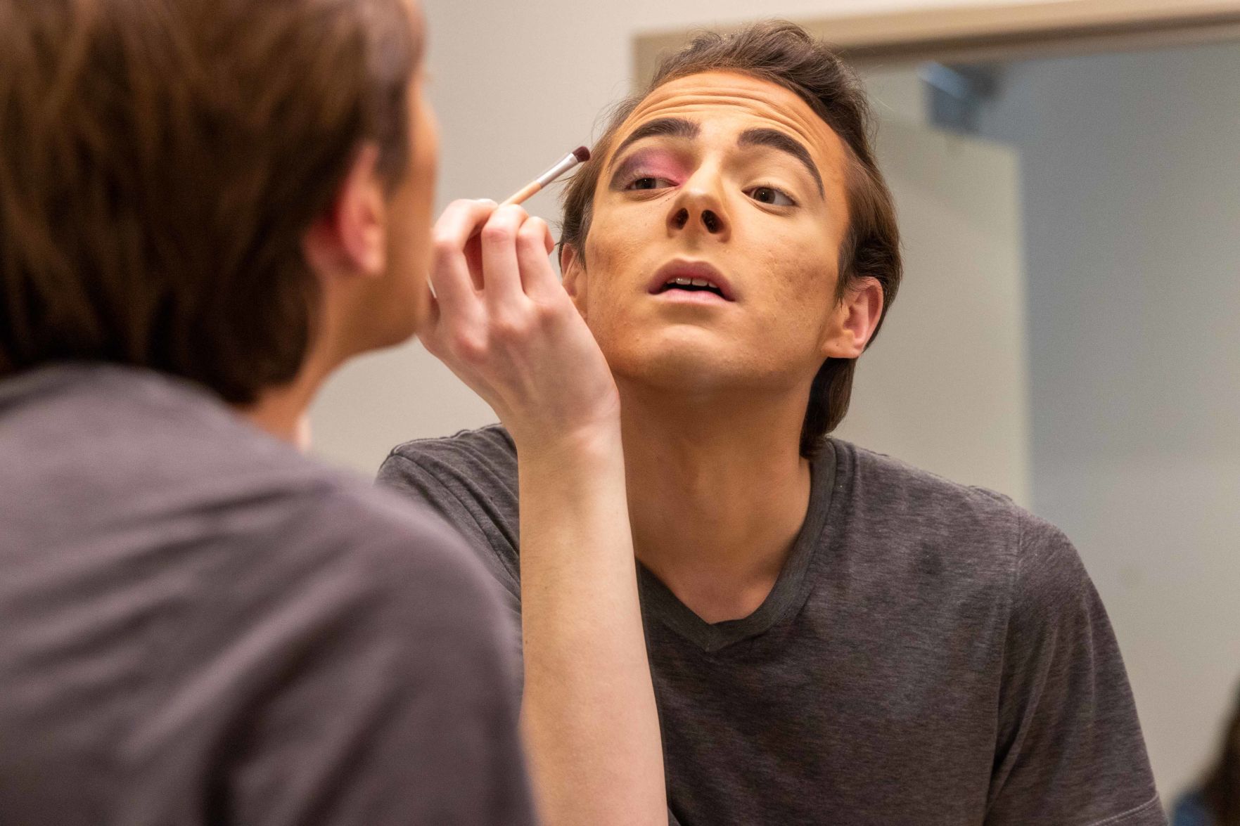 Sophomore Derek Dunn practices his makeup in the mirror (copy)